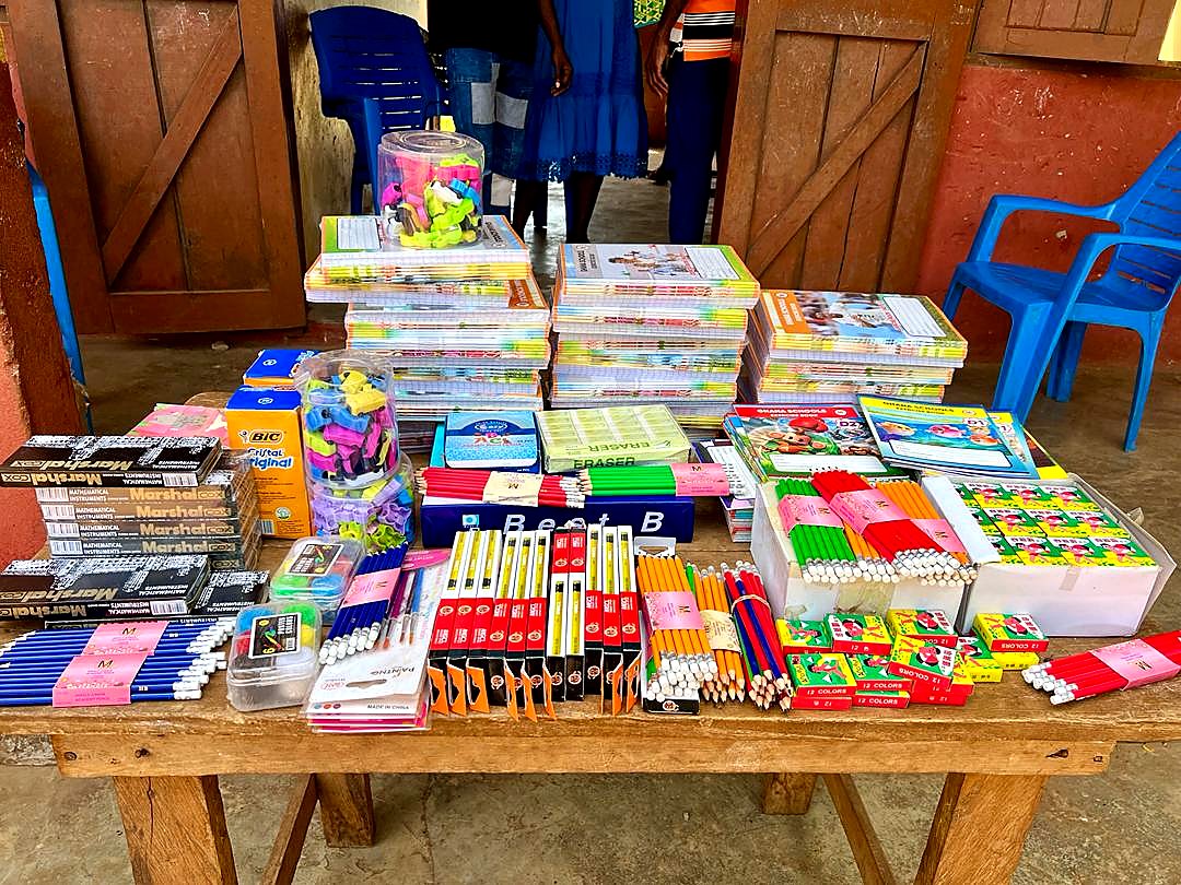 Exercise books, pencils, erasers, sharpeners, and other school materials arranged for distribution