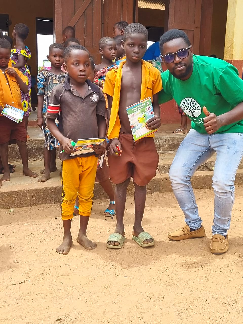 Students holding donated books with the Stone of Help Youth Foundation founder