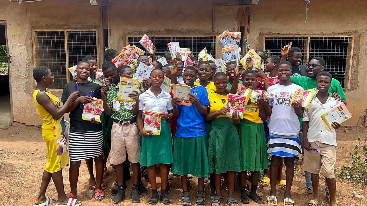 Students in Kpandai holding donated exercise books and school supplies