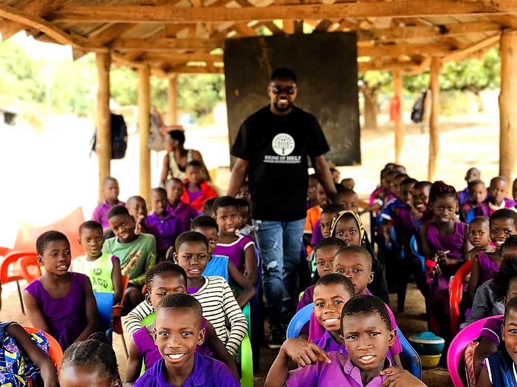 Stone of Help Youth Foundation founder with children during school outreach